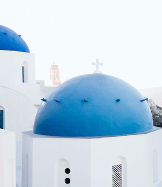 View of blue-domed buildings in Greece — travel insurance for international trips