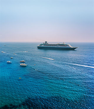 Consider cruise insurance coverage for trips like the one shown, with a cruise ship near the coastline.
