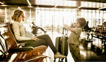 Mother at the airport for travel during pregnancy with her young son.