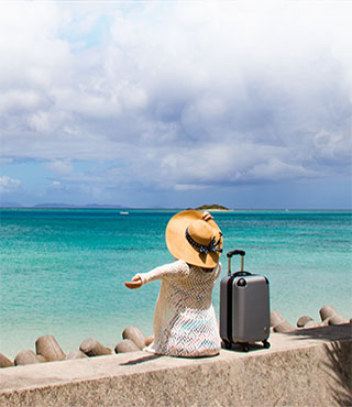 woman at beach with luggage