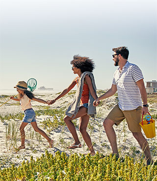 young family walking to beach