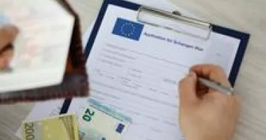Hand filling out application for Schengen visa