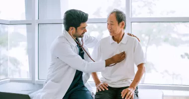 Doctor checking patient's heart at a travel health care appointment
