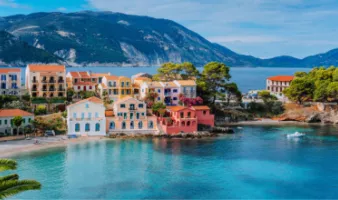Read our Europe travel guide before traveling to see this view of Assos village in Greece with colorful houses and a lagoon.