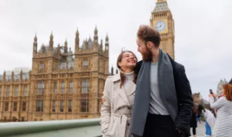 Smiling couple in front of Elizabeth Tower in London, which we tell you more about in our U.K. travel guide.