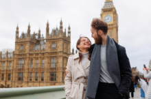 Smiling couple in front of Elizabeth Tower in London, which we tell you more about in our U.K. travel guide.