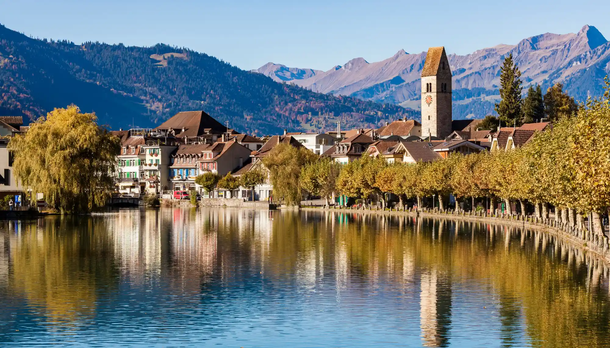 View of the Aare River and Old Town Interlaken in Switzerland, where you can use a Europe travel guide