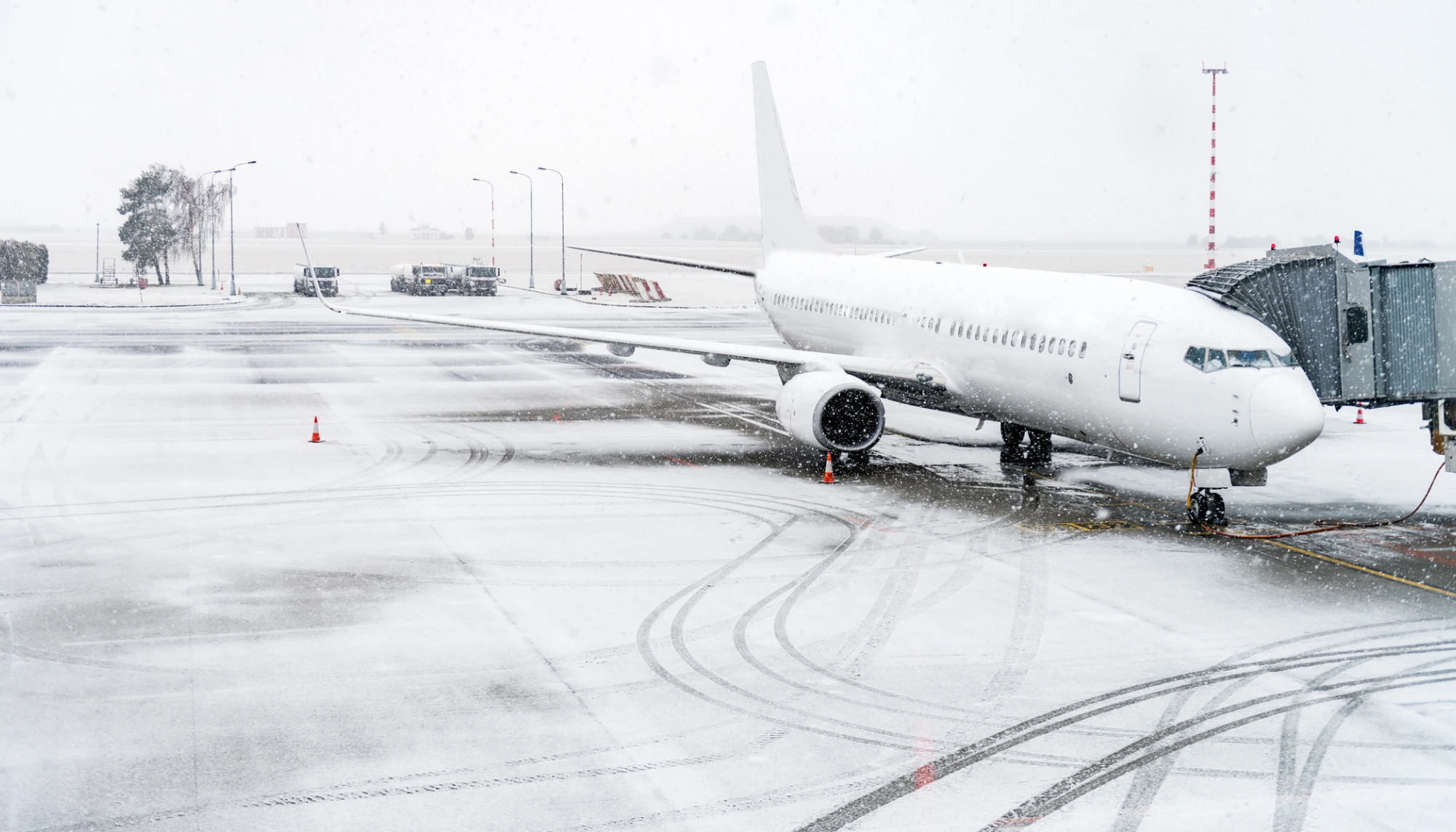 a grounded airplane in harsh winter weather, prompting the question, "Does travel insurance cover snowstorms?" 