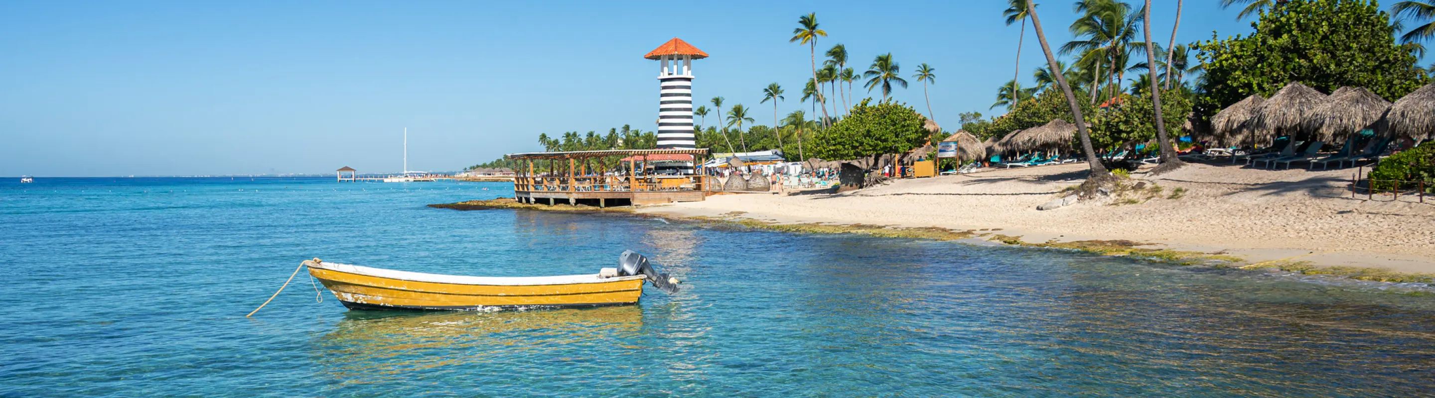 Small yellow boat anchored by the shore at the beach, highlighting travel insurance for Dominican Republic trips
