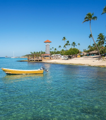 Small yellow boat anchored by the shore at the beach, highlighting travel insurance for Dominican Republic trips
