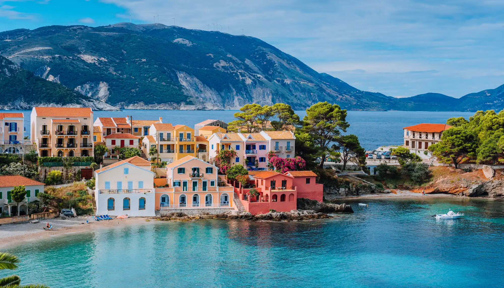 colorful buildings on the ocean with mountains in the background, featured in Travelex's Europe travel guide