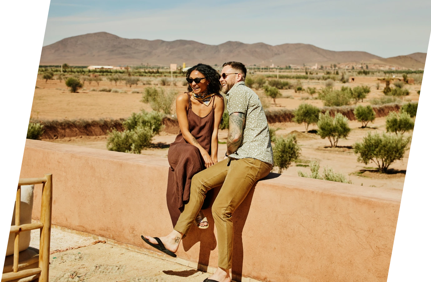 Couple with travel insurance for Africa sitting together with the desert in the background
