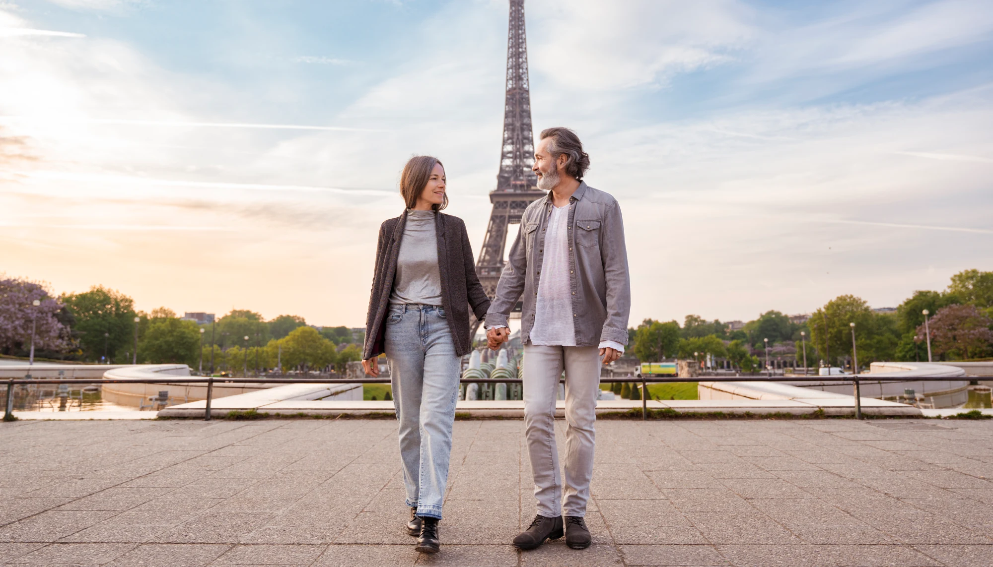 middle-aged couple holding hands in front of the Eiffel Tower in Paris, one of the most romantic places in the world