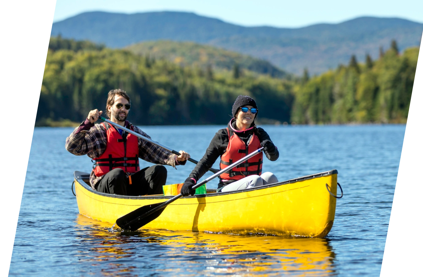 Man and woman kayaking in a lake with travel insurance for Canada