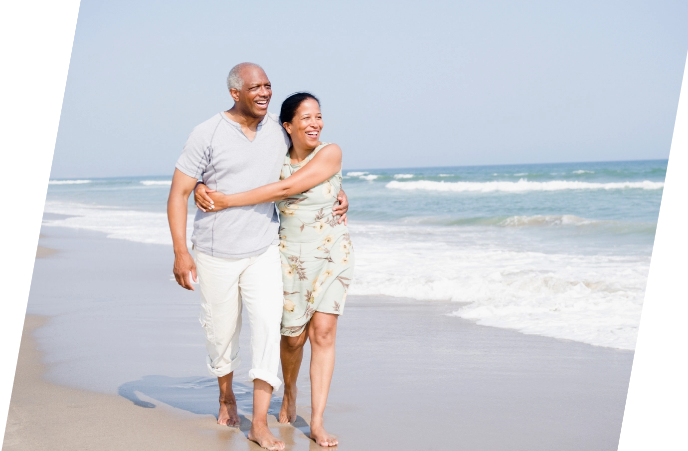 a couple with travel insurance for New York, enjoying a walk on the beach in the Hamptons 