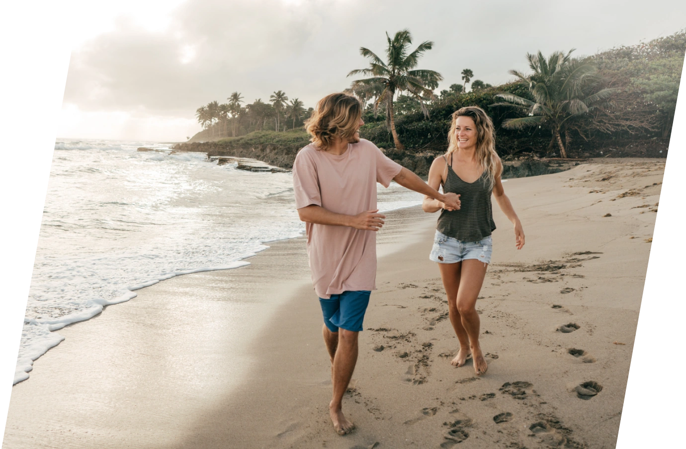 Young couple running and laughing on the beach with travel insurance for their Dominican Republic trip