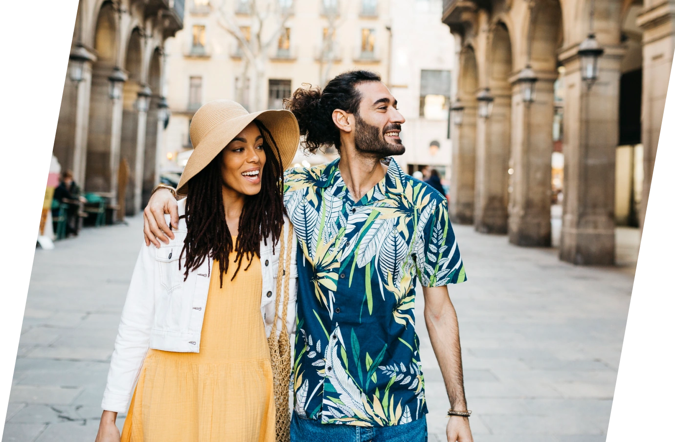 a young couple with travel insurance for Spain, walking through an old quarter 