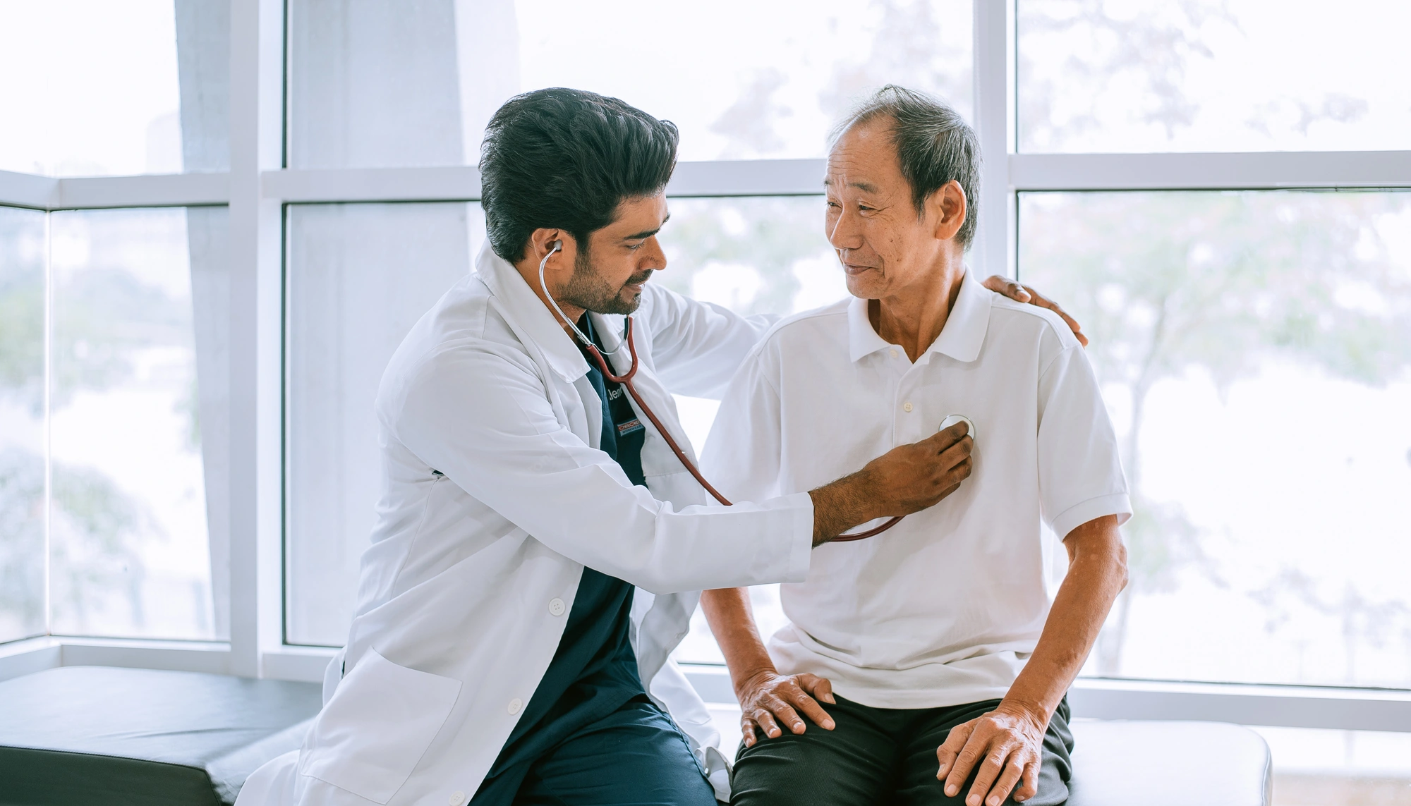 Doctor checking a patient's heart with a stethoscope and providing travel health care abroad