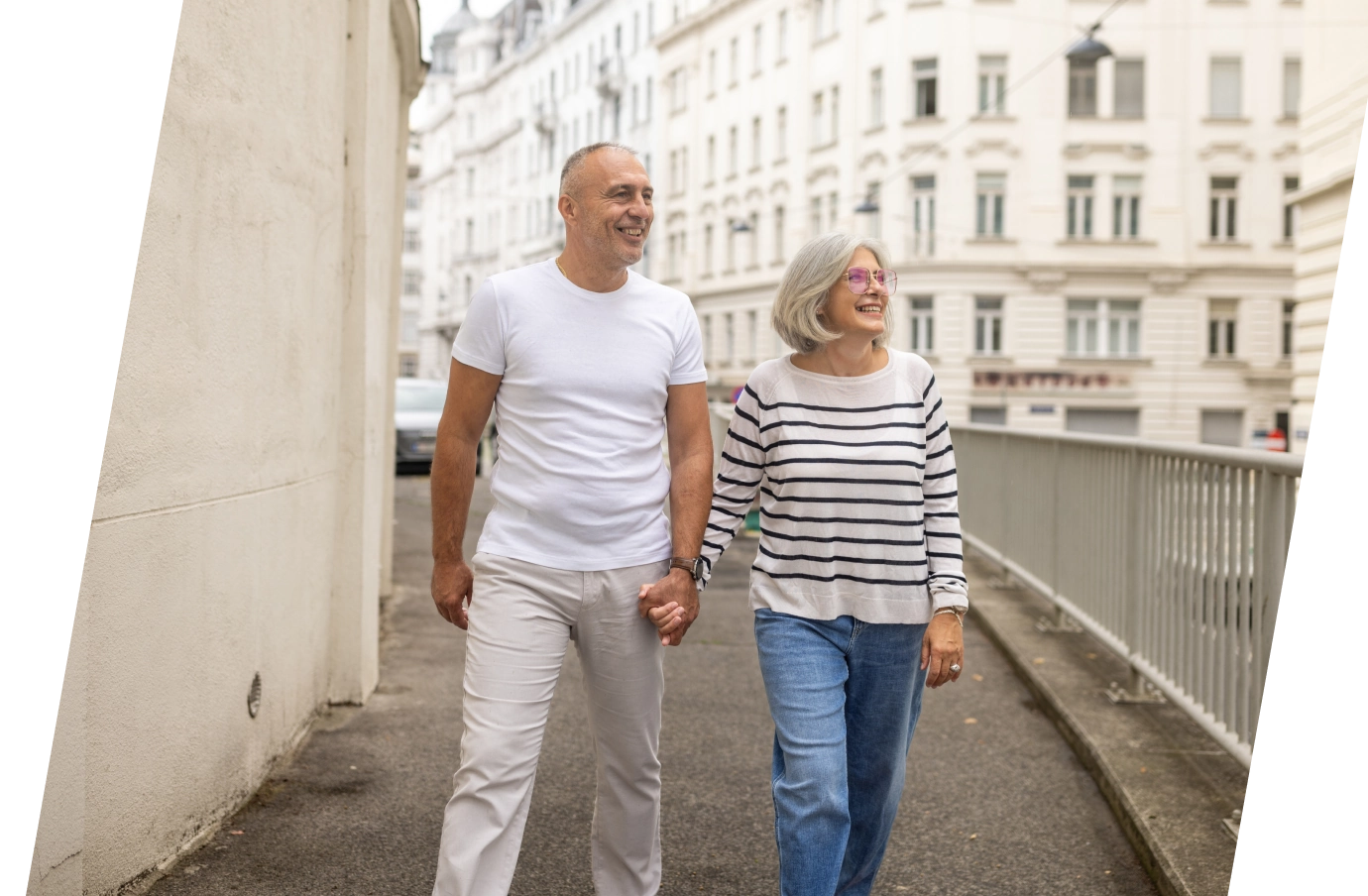 an elderly couple holding hands as they walk through the streets of Vienna, insured with travel insurance for Austria 