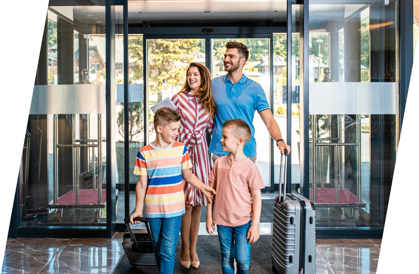 Parents with travel insurance for their all-inclusive trip walking into a hotel lobby with their two sons