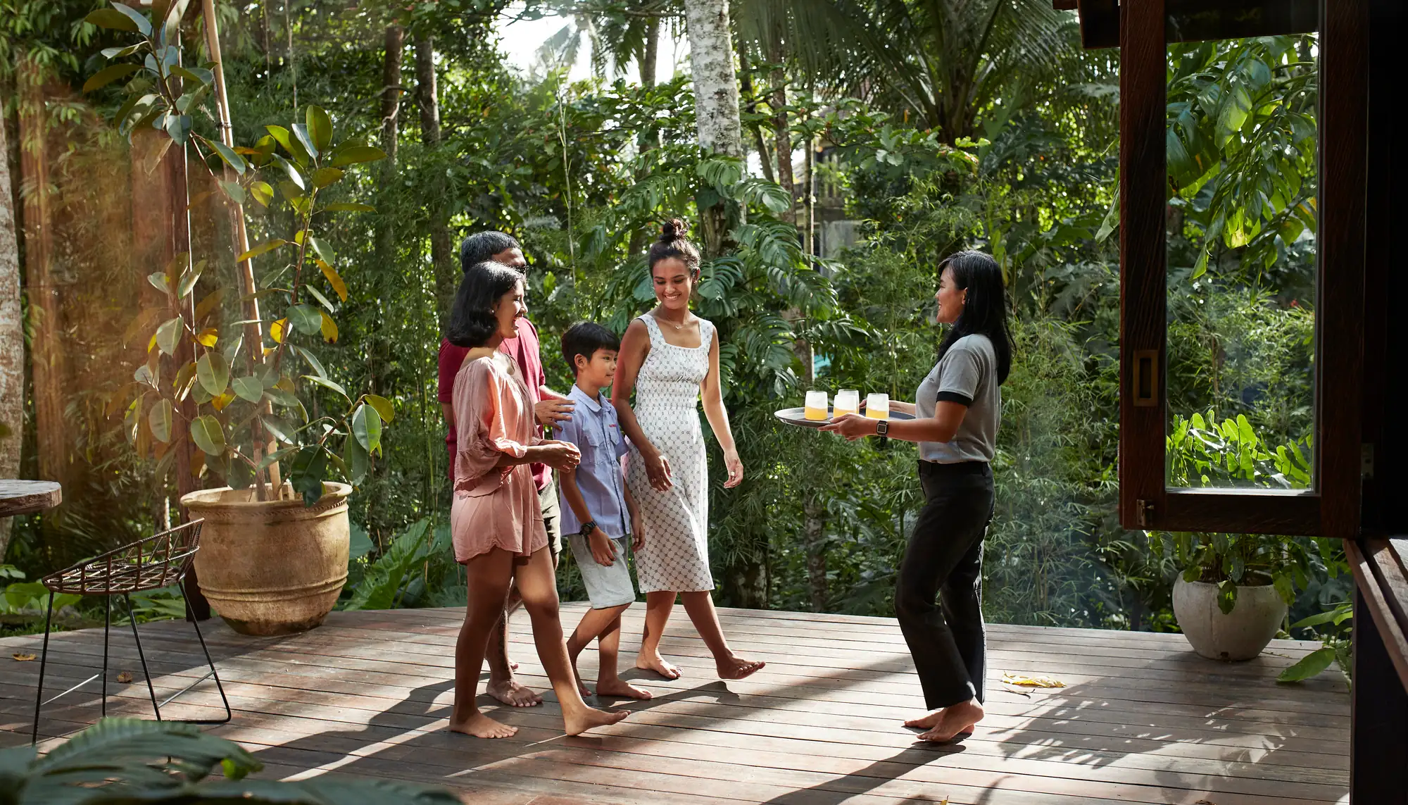 a family walking toward a hotel offering welcome drinks, after researching whether all-inclusive resorts are worth it