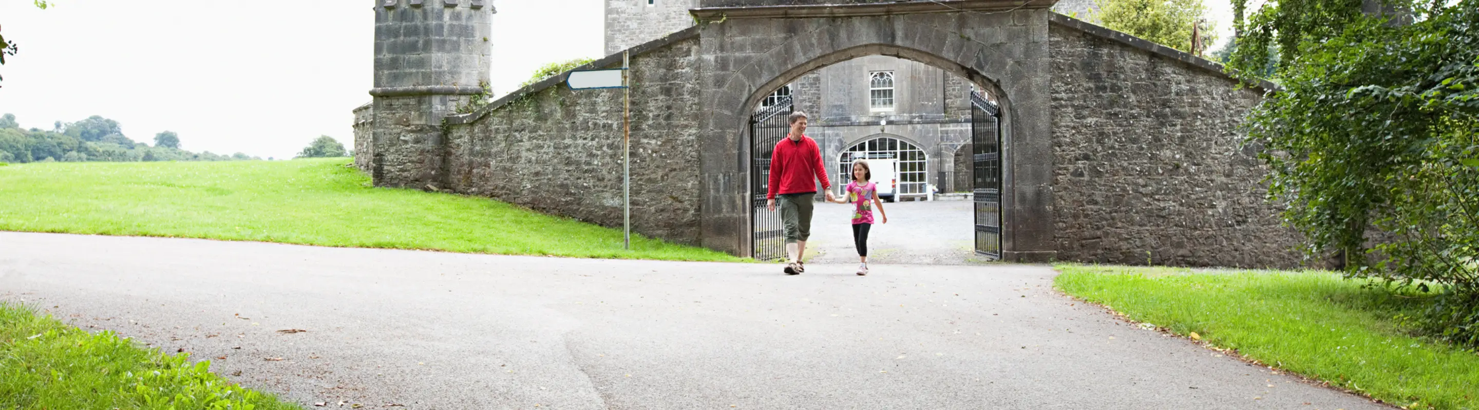 Father with travel insurance for Ireland holding hands with his daughter and walking out of Slane Castle