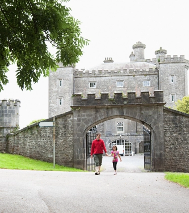 Father with travel insurance for Ireland holding hands with his daughter and walking out of Slane Castle