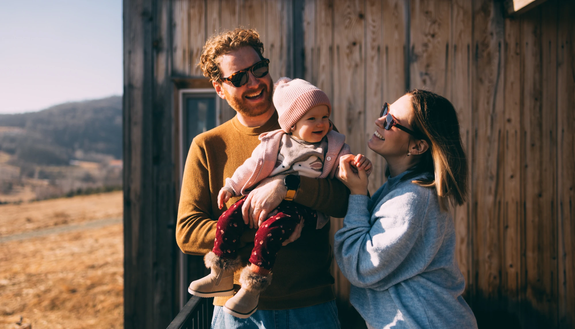 parents holding their toddler on vacation after reading up on the best places to travel to with a baby