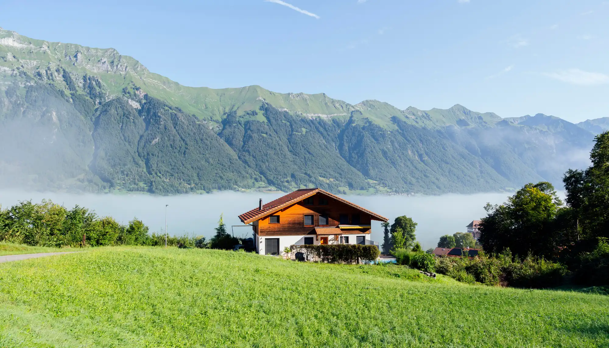 View of a home set against the mountains in Switzerland, one of the most romantic places for couples to travel
