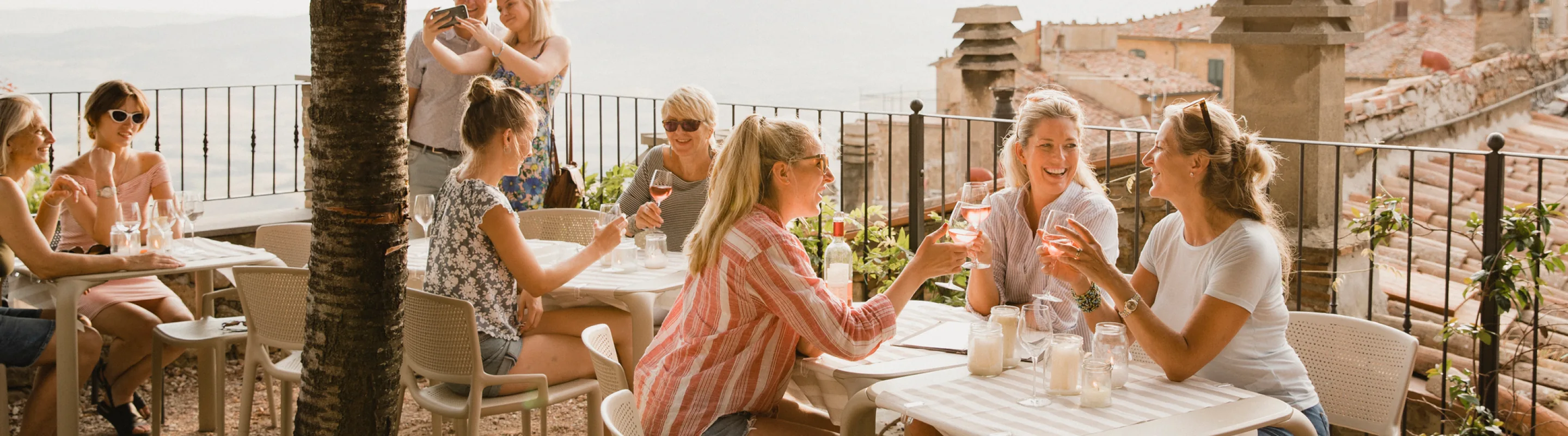ladies with travel insurance for Europe, enjoy wine at a restaurant in the Mediterranean 