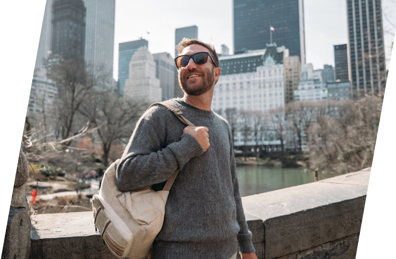 a man with travel insurance for New York, wearing a backpack and sunglasses in Central Park 