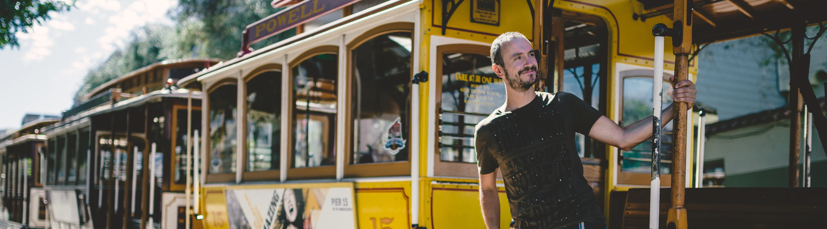 a man catches a yellow cable car in downtown San Francisco, insured with travel insurance for California