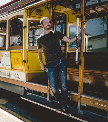 a man catches a yellow cable car in downtown San Francisco, insured with travel insurance for California