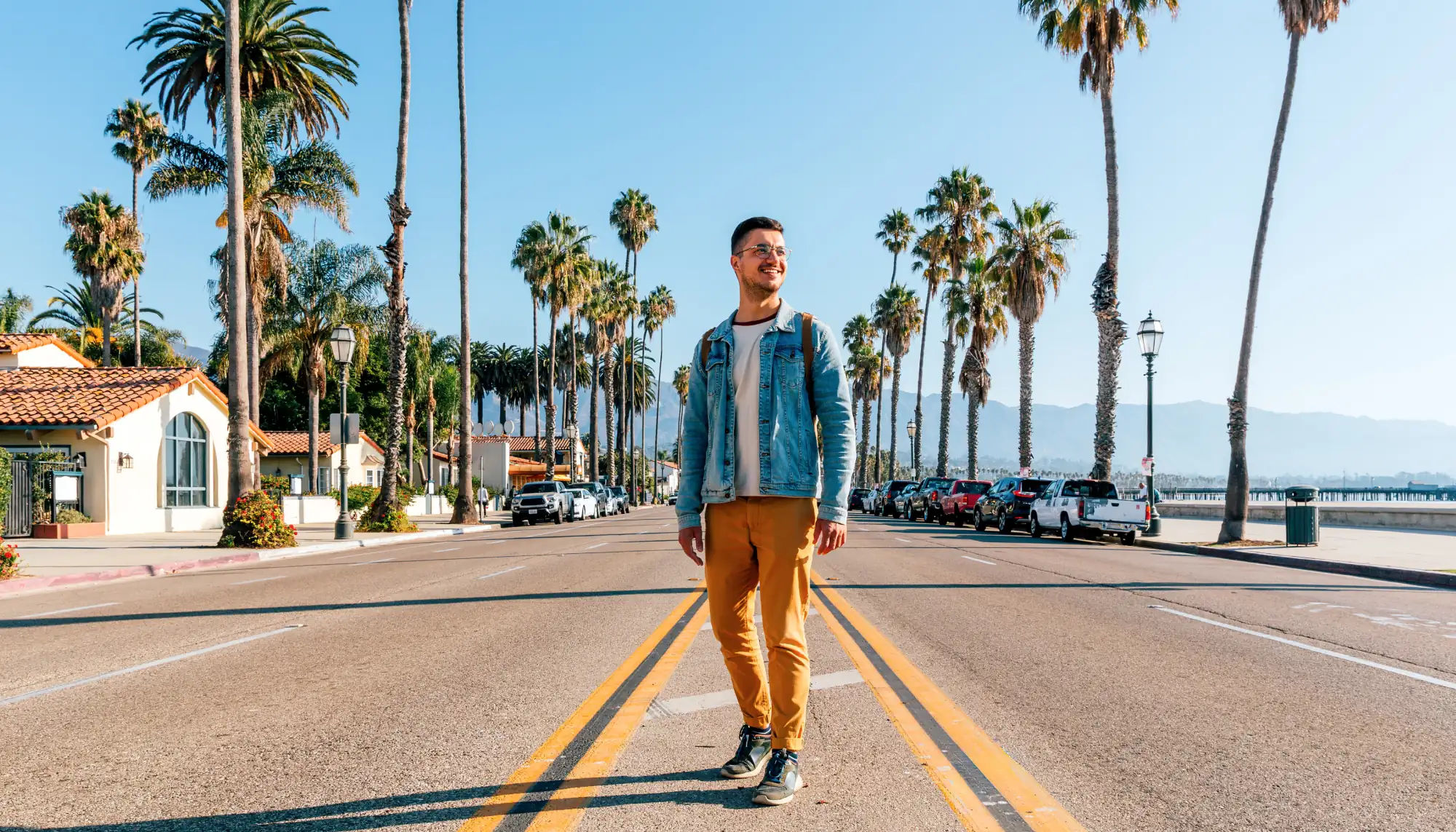 a young man wearing a jean jacket and yellow pants on Cabrillo Boulevard, Santa Barbara, a place in many U.S. travel guides