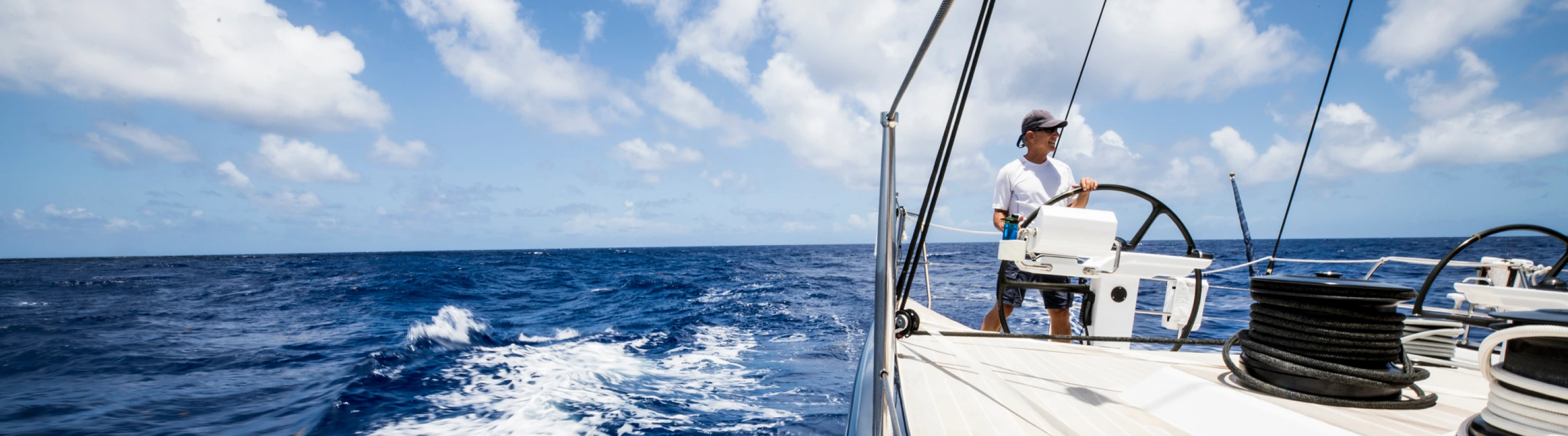 Man with travel insurance for the Bahamas driving a boat in the ocean to go deep sea fishing