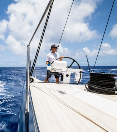 Man with travel insurance for the Bahamas driving a boat in the ocean to go deep sea fishing