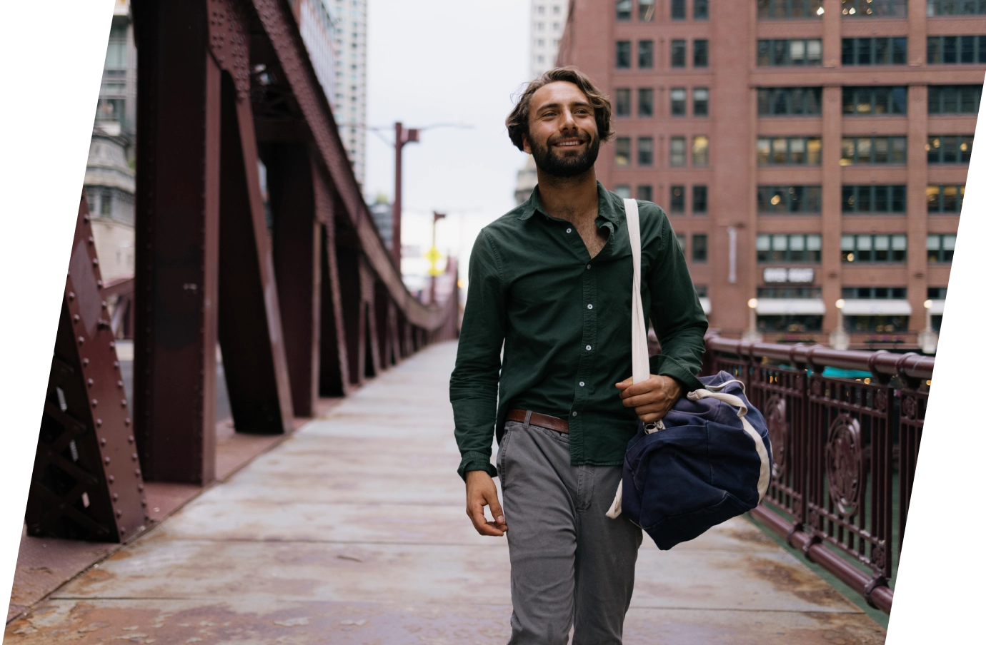 a man walks across one of the iconic red steel truss bridges in downtown Chicago with travel insurance for Illinois