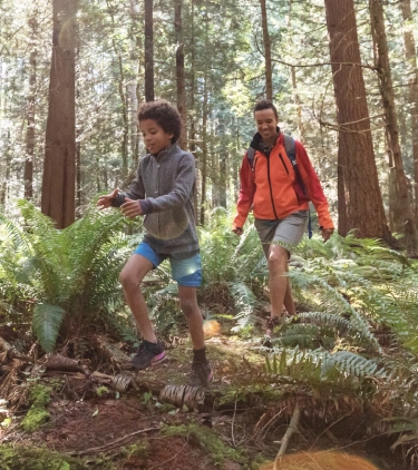Mother with travel insurance for Canada hiking in the forest with her son