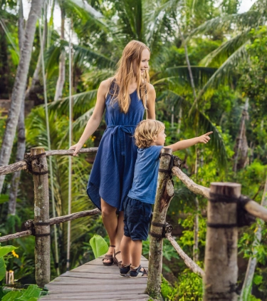 a mother-son duo with travel insurance for the Philippines, birdwatching in a tropical rainforest  
