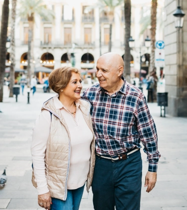 an older couple walking through a historic town with travel insurance for Spain