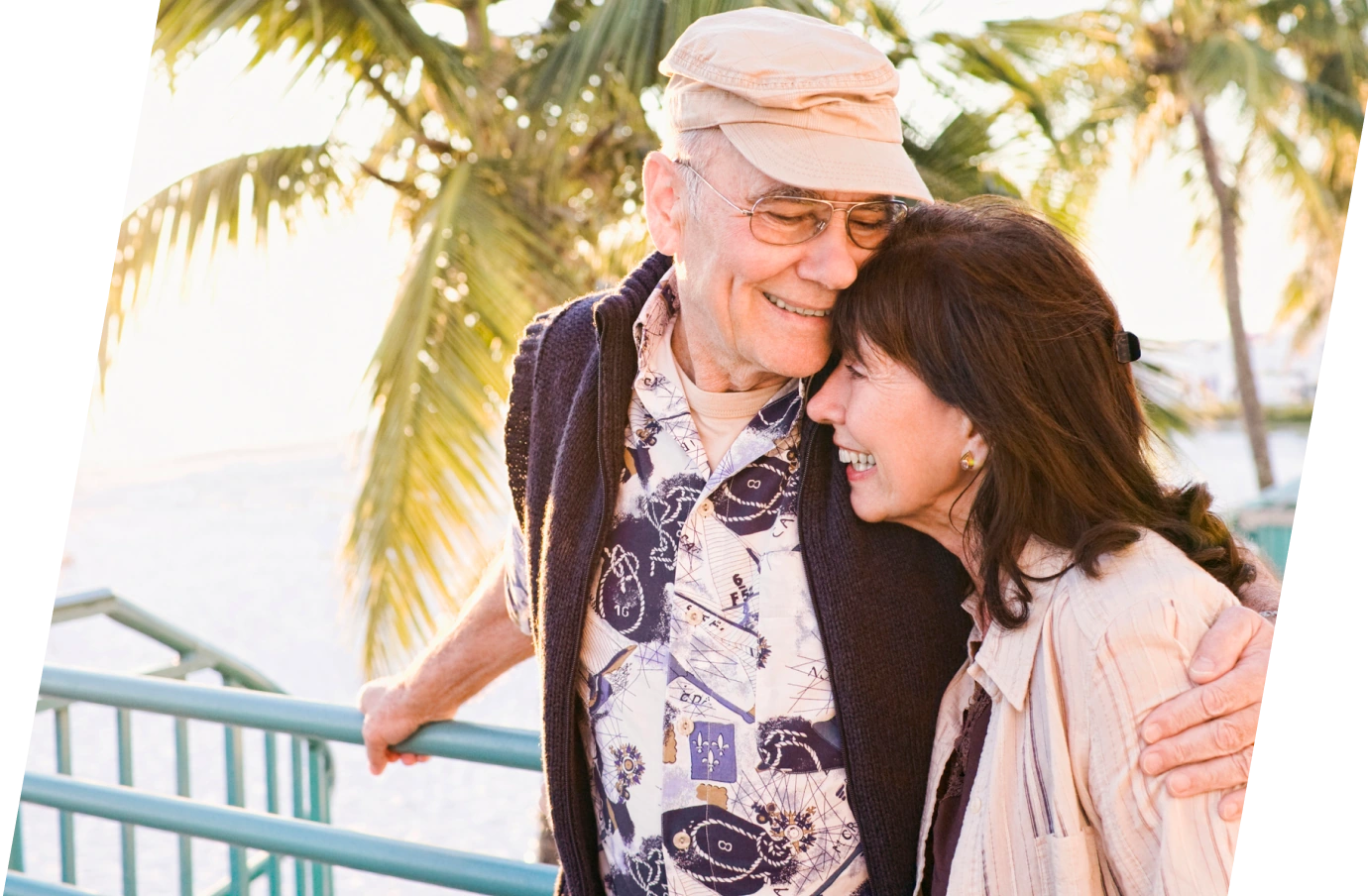 Senior couple with travel insurance for Florida embracing and smiling by the beach