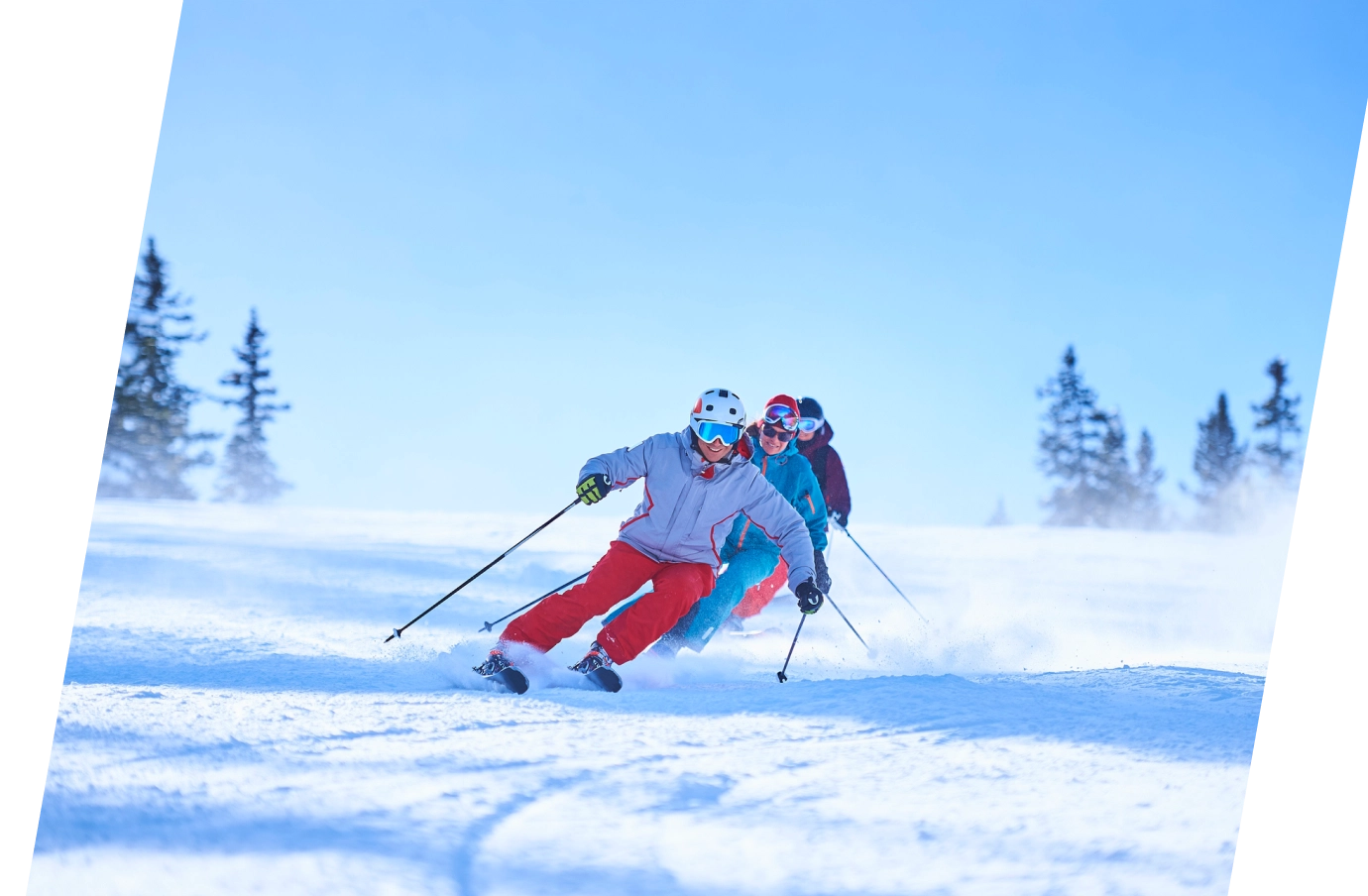 three travelers in snow gear ski down a snowy slope on a winter vacation, insured with adventure travel insurance 