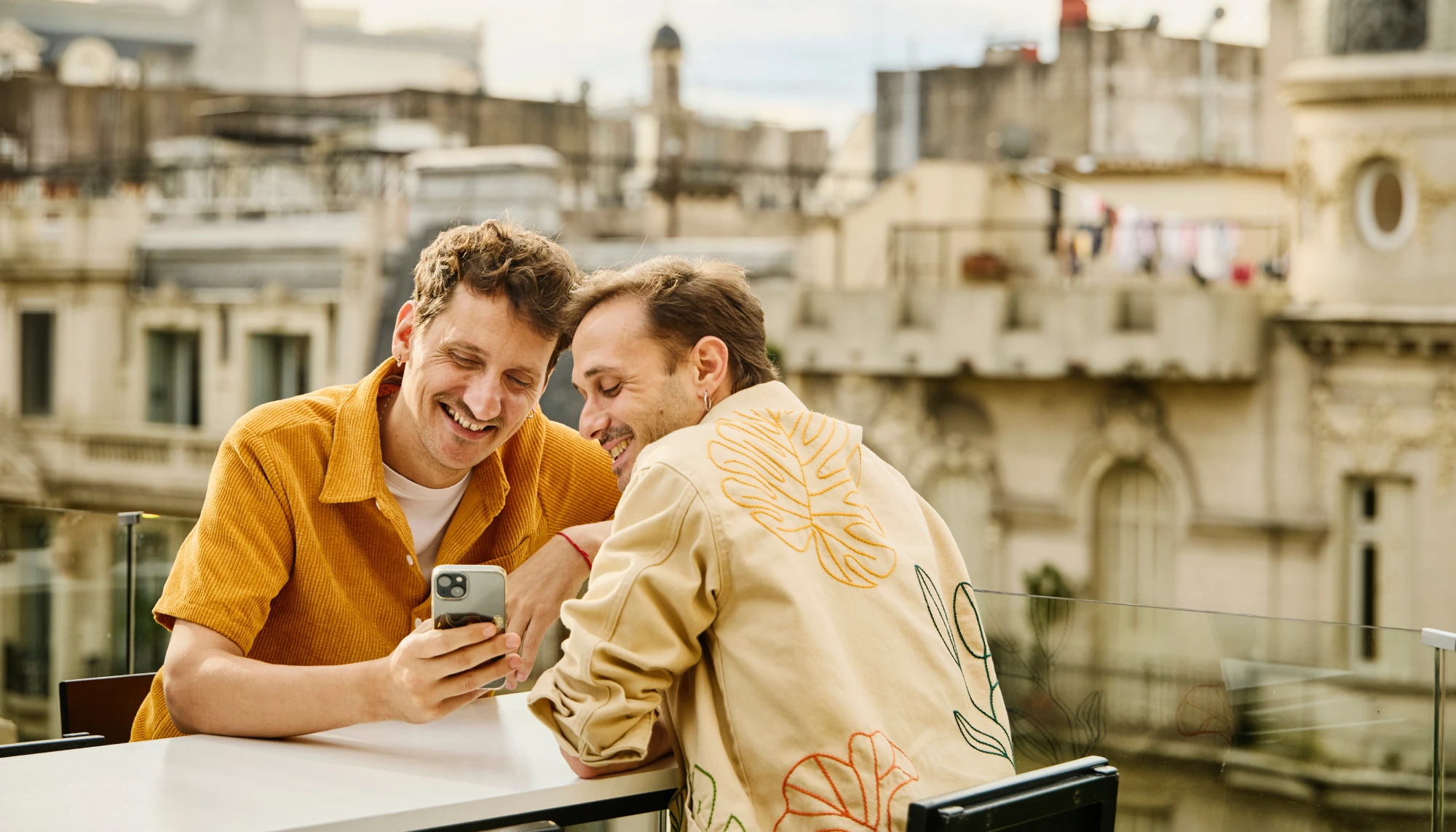Two men in an ancient town in South America, looking at Travelex's travel app for safety tips and policy info