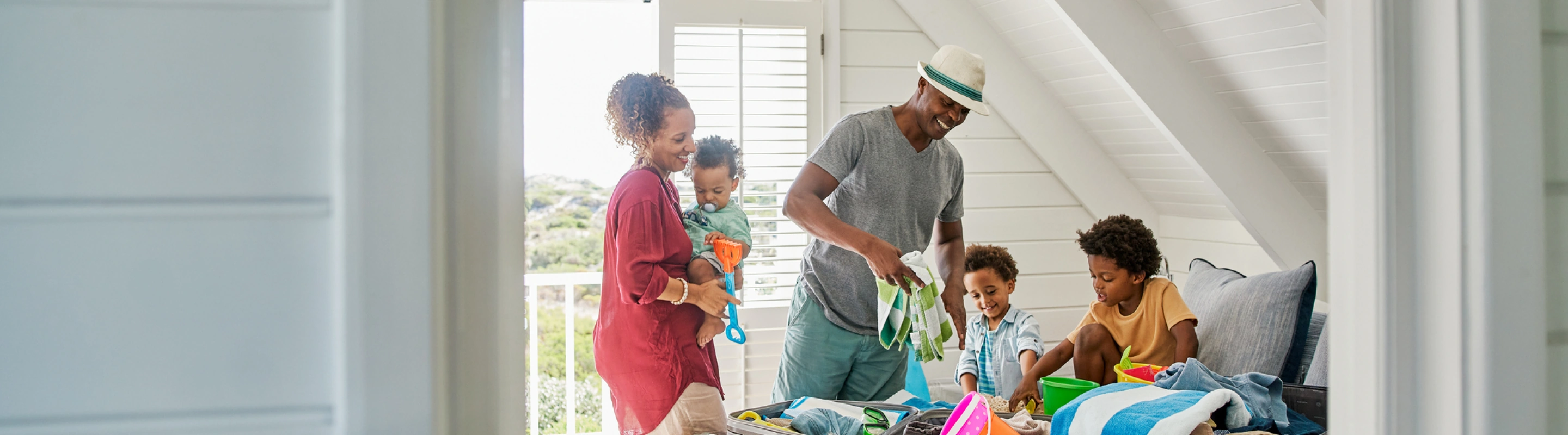 a mixed-race family of five with family travel insurance, unpacking and getting ready for a beach day at their vacation rental
