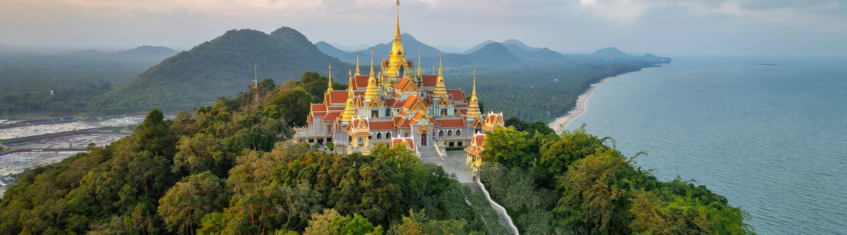 Aerial view of hilltop Wat Tang Sai temple with water and hills in the background highlighting travel insurance for Thailand