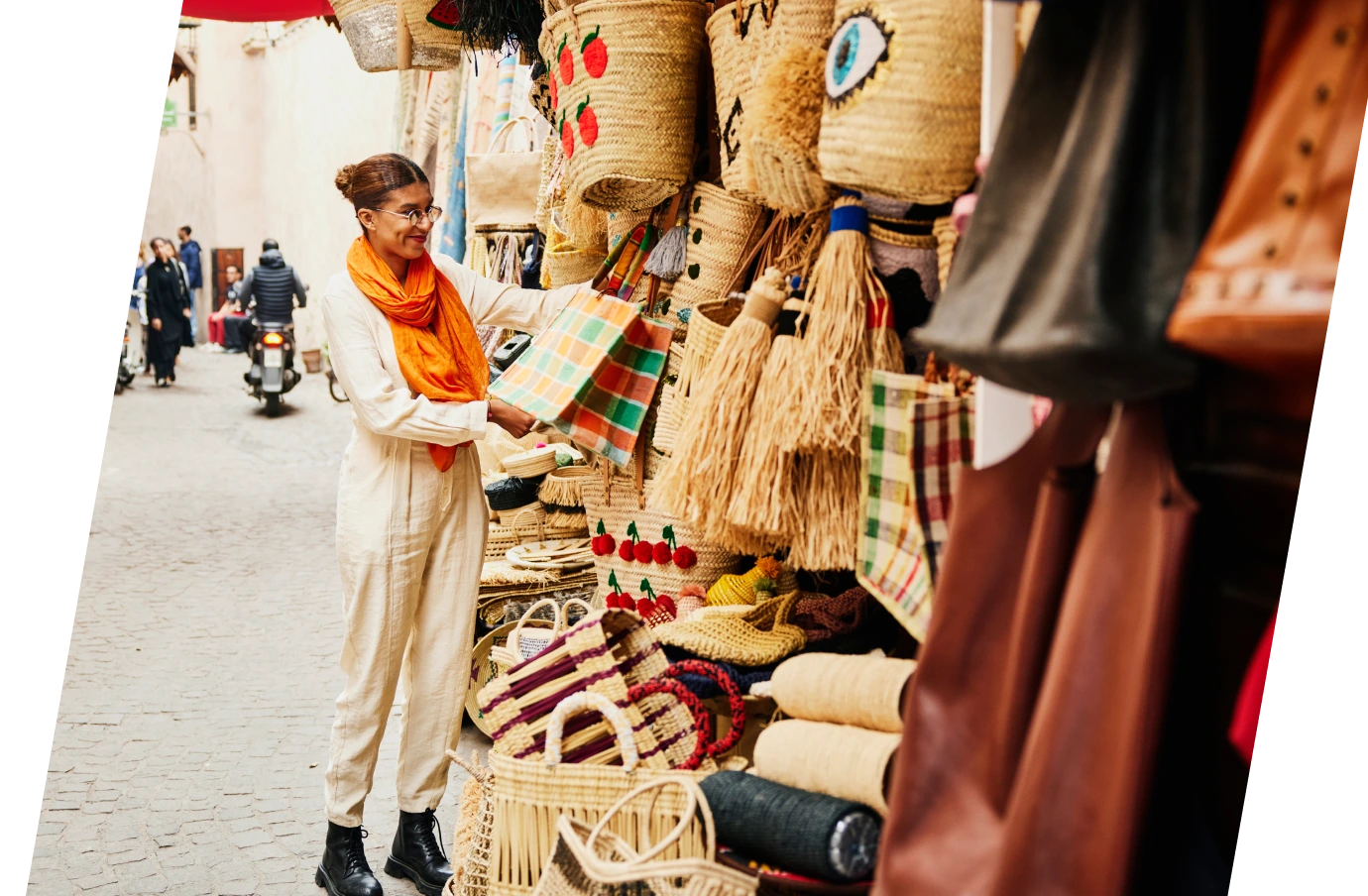 Woman with travel insurance for Africa shopping for bags at an outdoor market