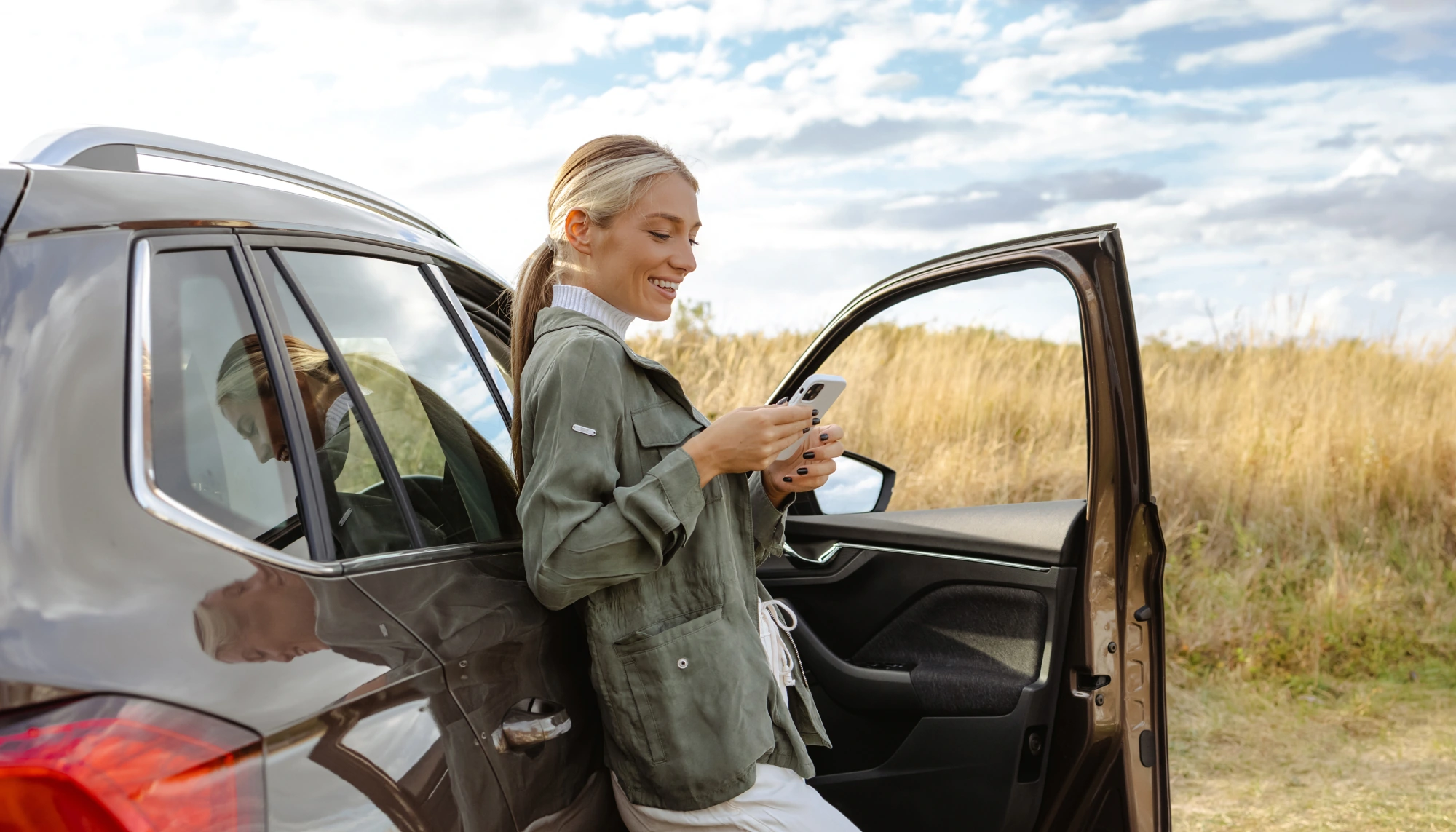 woman standing outside her car and calling for help after getting into a vehicle accident on vacation