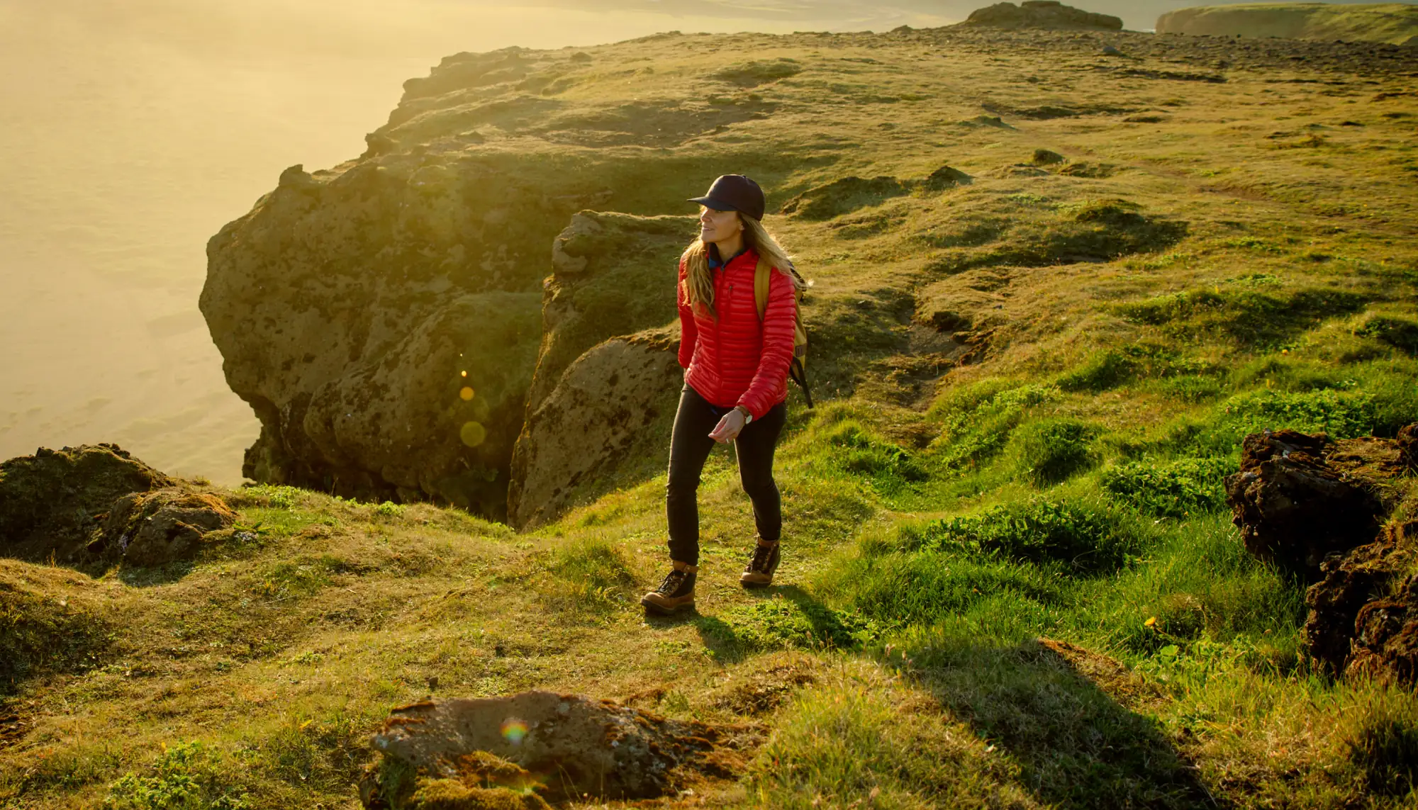 Woman hiking at the edge of a cliff in Iceland, one of the best solo travel destinations