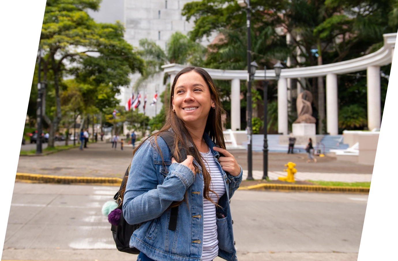 woman with travel insurance for Costa Rica, walking around a city in Costa Rica with a backpack and smile on her face