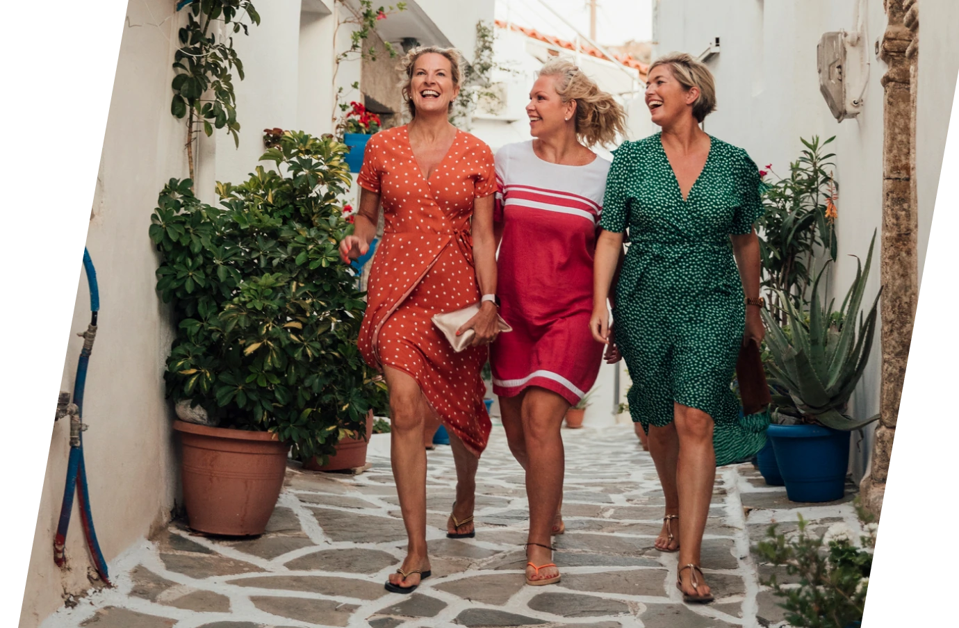 a group of women with travel insurance for Greece, walking down a cobblestone street 